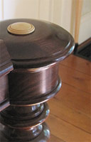 Newel post turned from a piece of reclaimed Black Walnut with brass inset.
